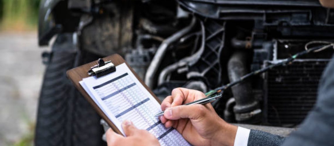 Insurance Agent Examining Car After Accident Or Crash